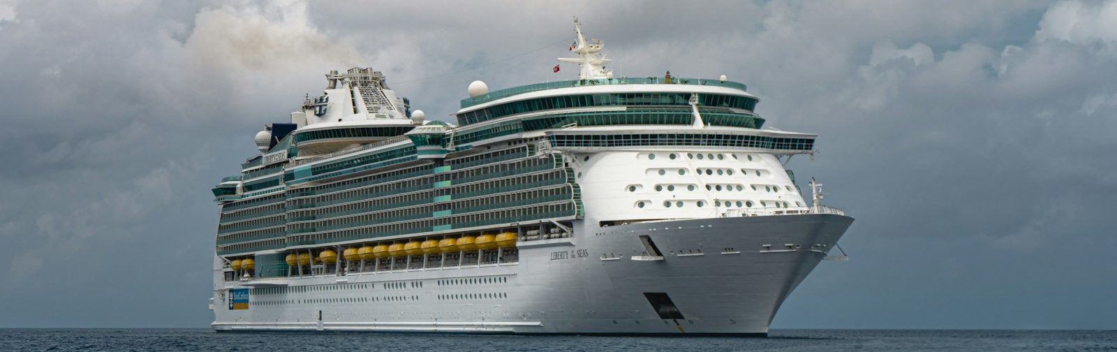 white cruise ship on sea under white clouds and blue sky during daytime