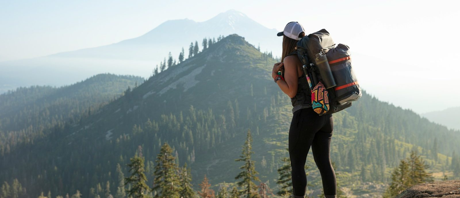 man in black jacket and black pants wearing black backpack standing on rocky mountain during daytime